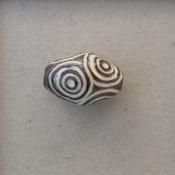 White circles on large dark oval bead