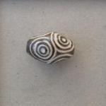 White circles on large dark oval bead