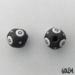 White circles on dark clay, round bead